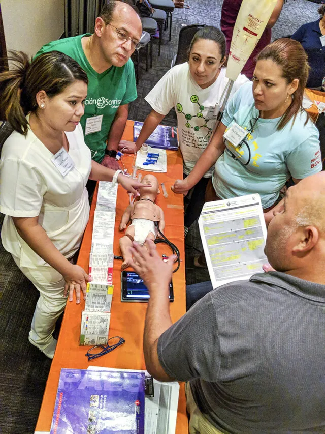 Nurses and anesthesiologists from Panama, Colombia and Bolivia listen to a case scenario presented by Paraguayan pediatrician Dr. Gustavo Zaracho, bottom right, during a PALS course.