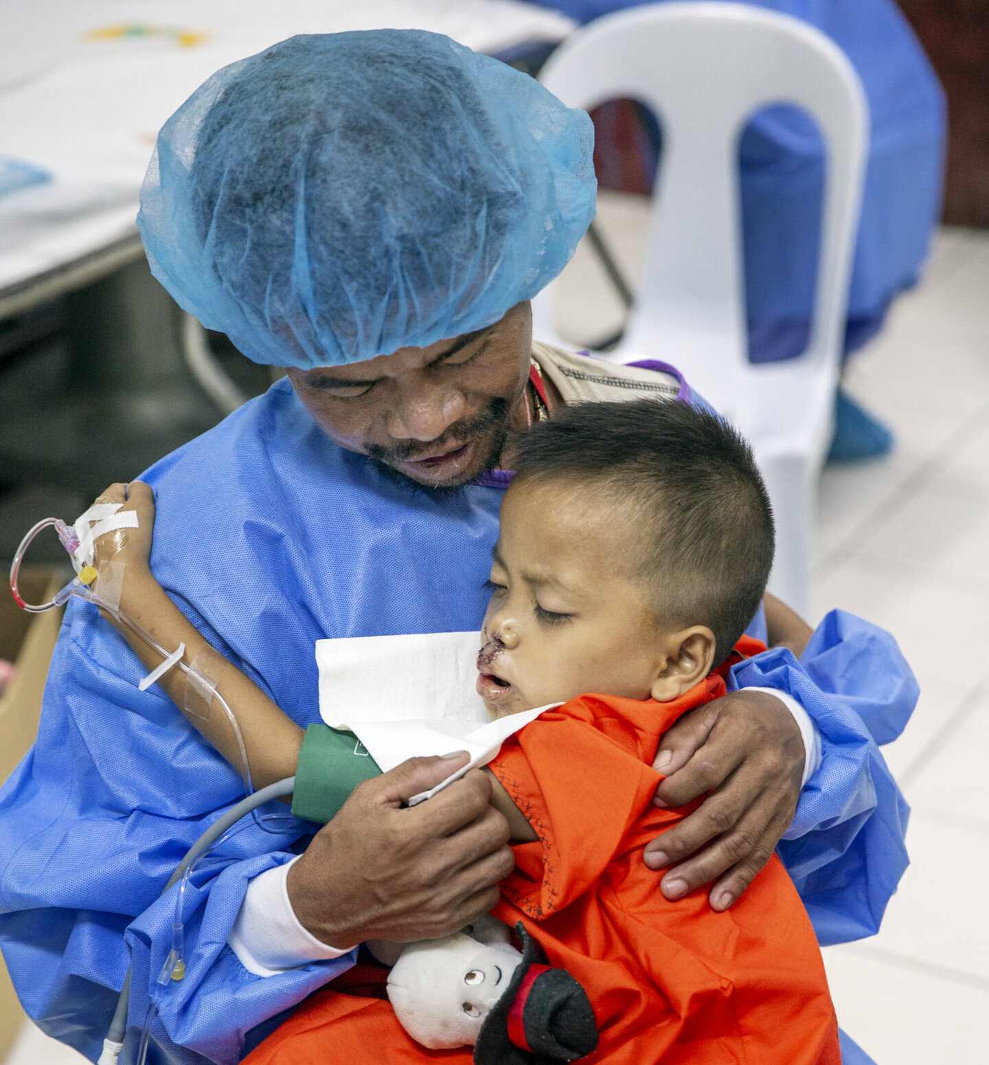 Joseph's father holds him after his surgery.