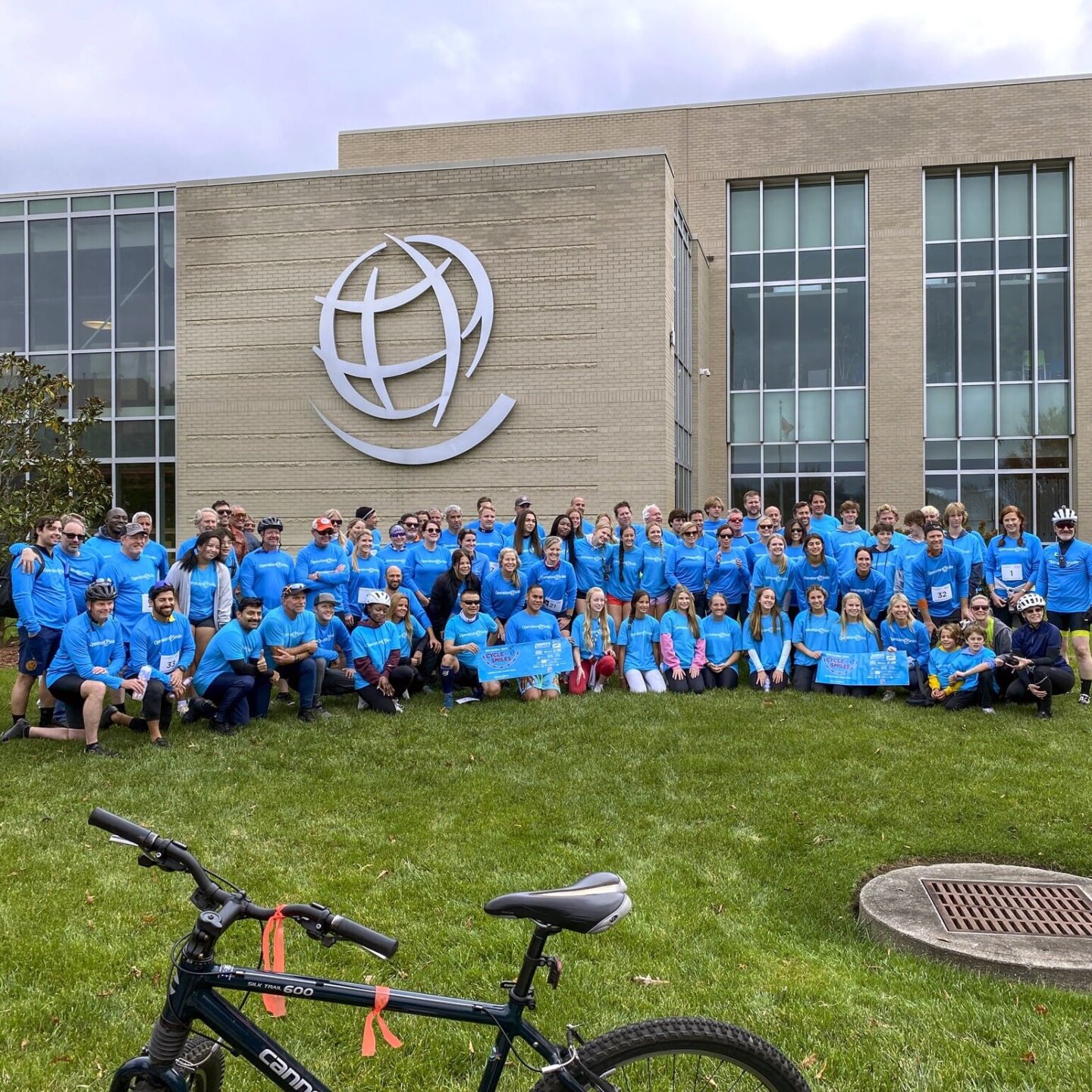 Cyclists post for a photo in front of Operation Smile headquarters in Virginia Beach, Virginia, after completing Cycle4Smiles.