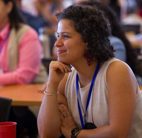 Tereza smiles while listening to a presentation