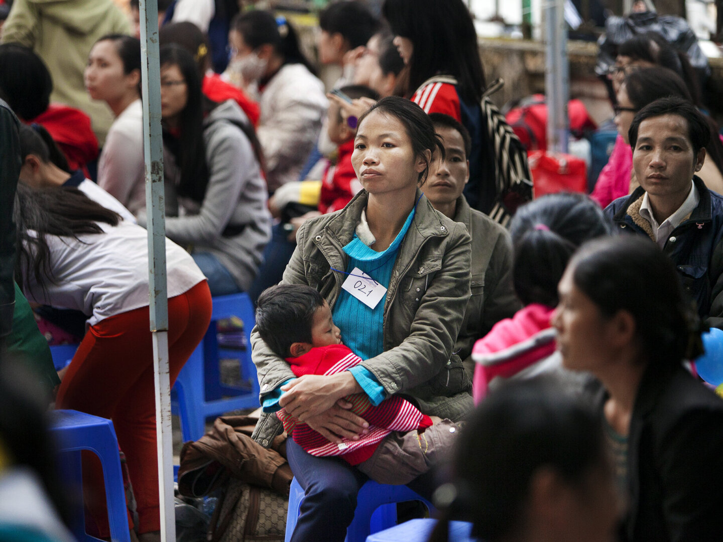 Bui's mom holds him as he waits during a surgical program in 2014 in Hanoi, Vietnam.