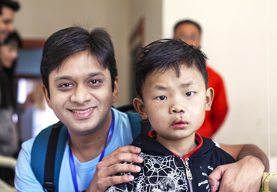 Dr. Deshpande smiles with a patient during a surgical program in China.