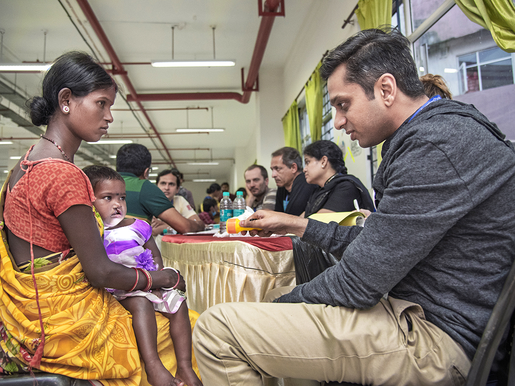 Dr. Deshpande talks with a patient and her mother during a surgical program in India.