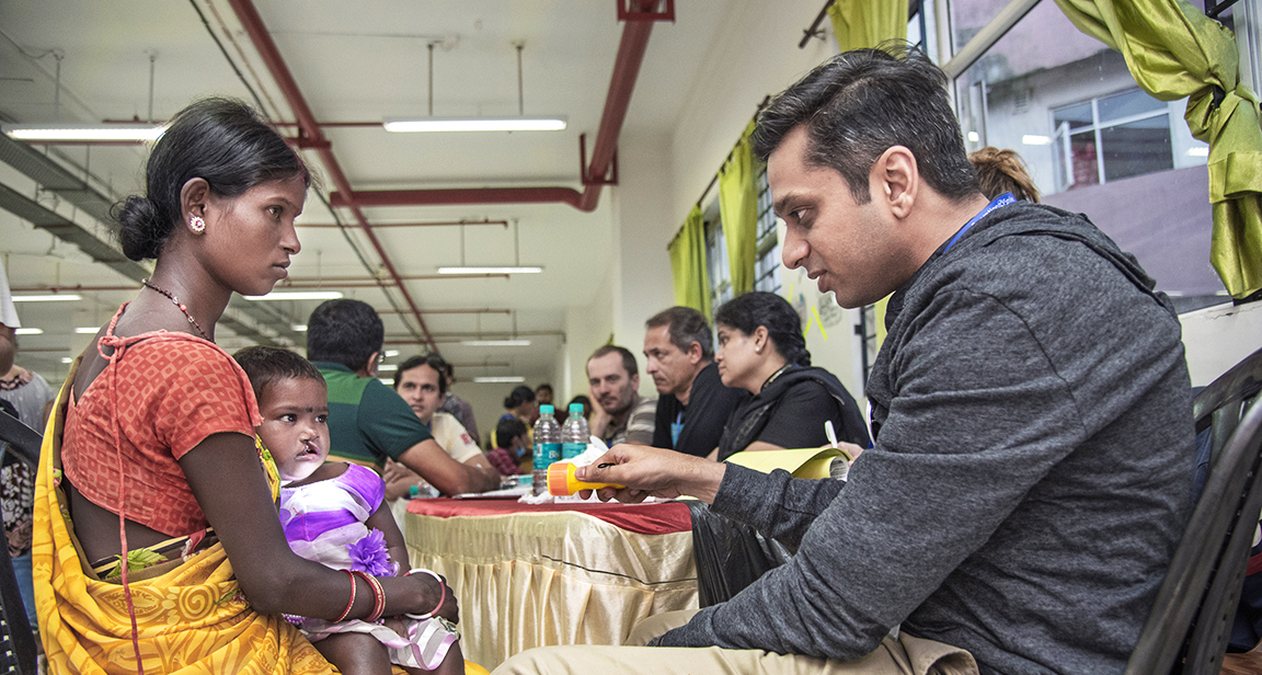 Dr. Deshpande talks with a patient and her mother during a surgical program in India.