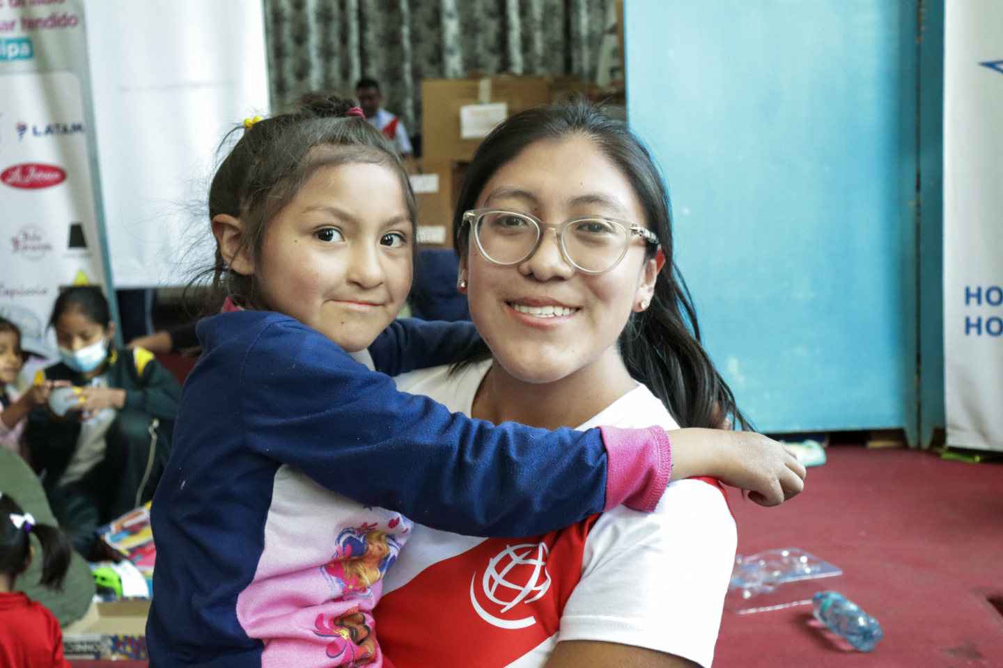 Angeles holds a patient and smiles for the camera during a surgical program in Peru.