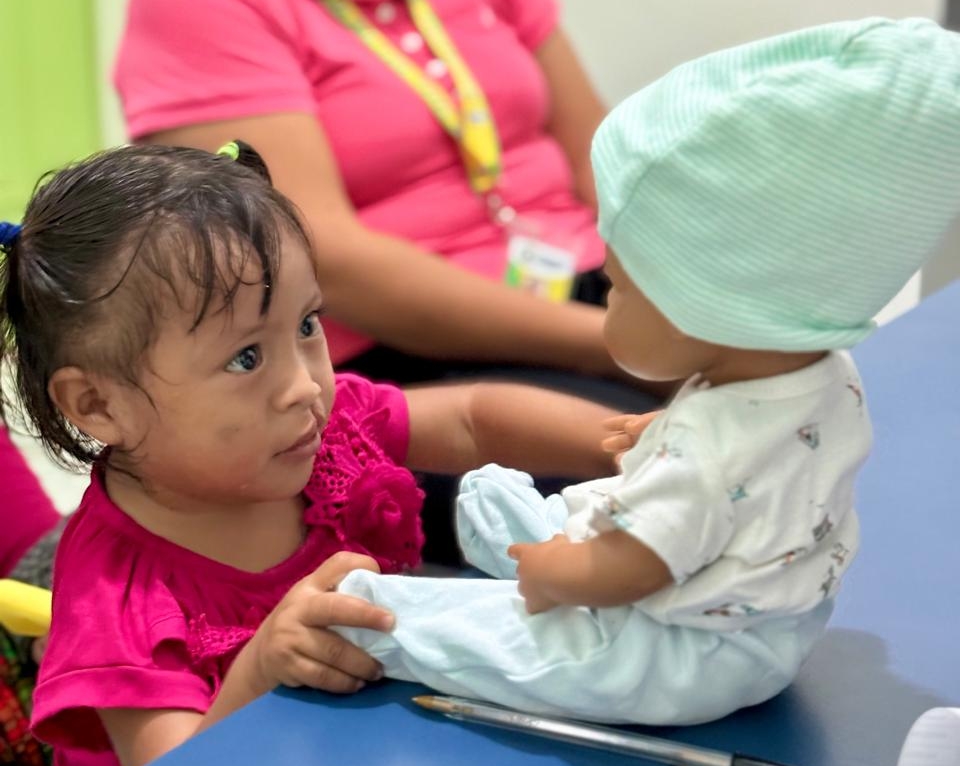 A patient looks a cleft doll in Guatemala.