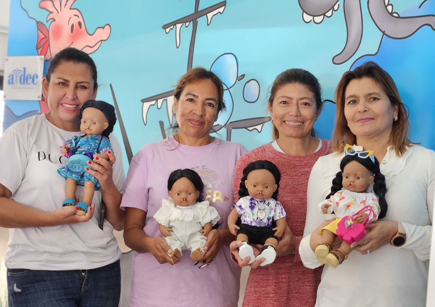 Volunteers pose with cleft dolls in Guatemala.