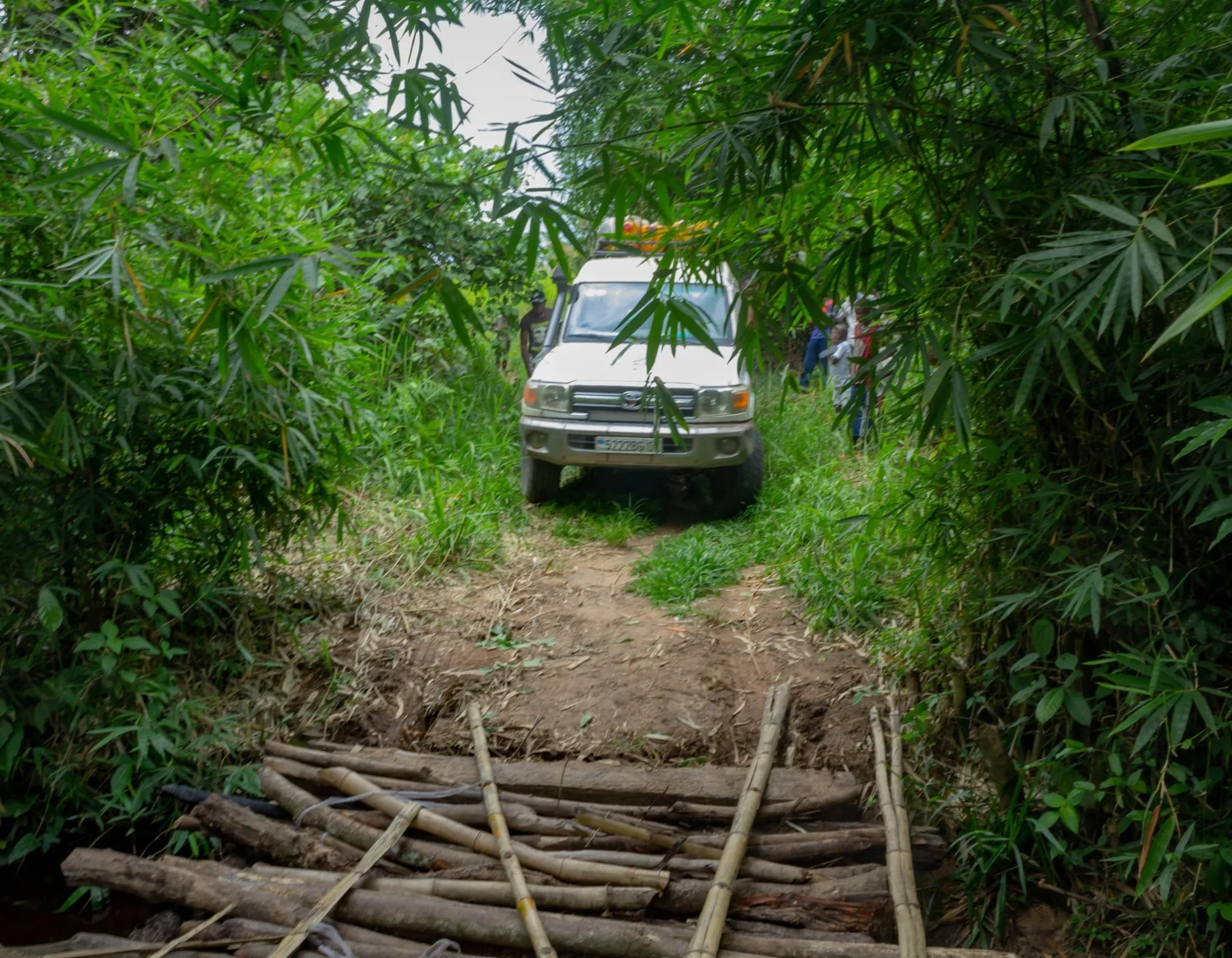 A vehicle in the DRC crosses a make-shift bridge.