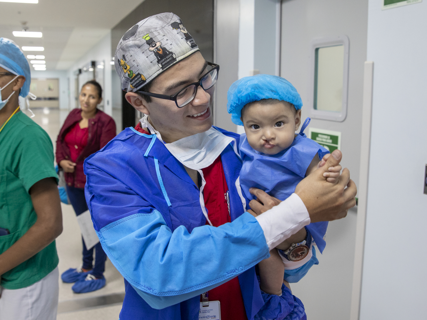 A patient looks at the camera with a volunteer in Operation Smile Ecuador.