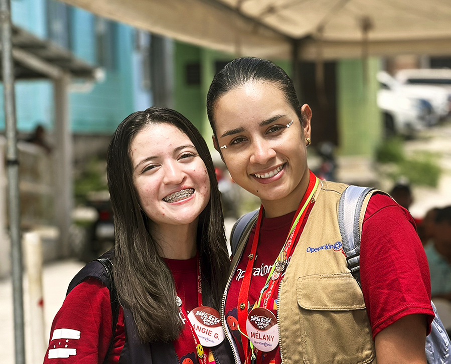 Angie smiles with a friend during a surgical program.