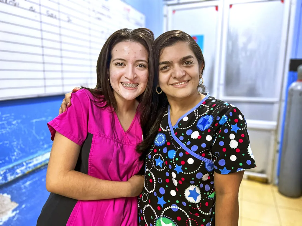 Student Volunteer Angie smiles with a friend during a surgical program in Honduras.