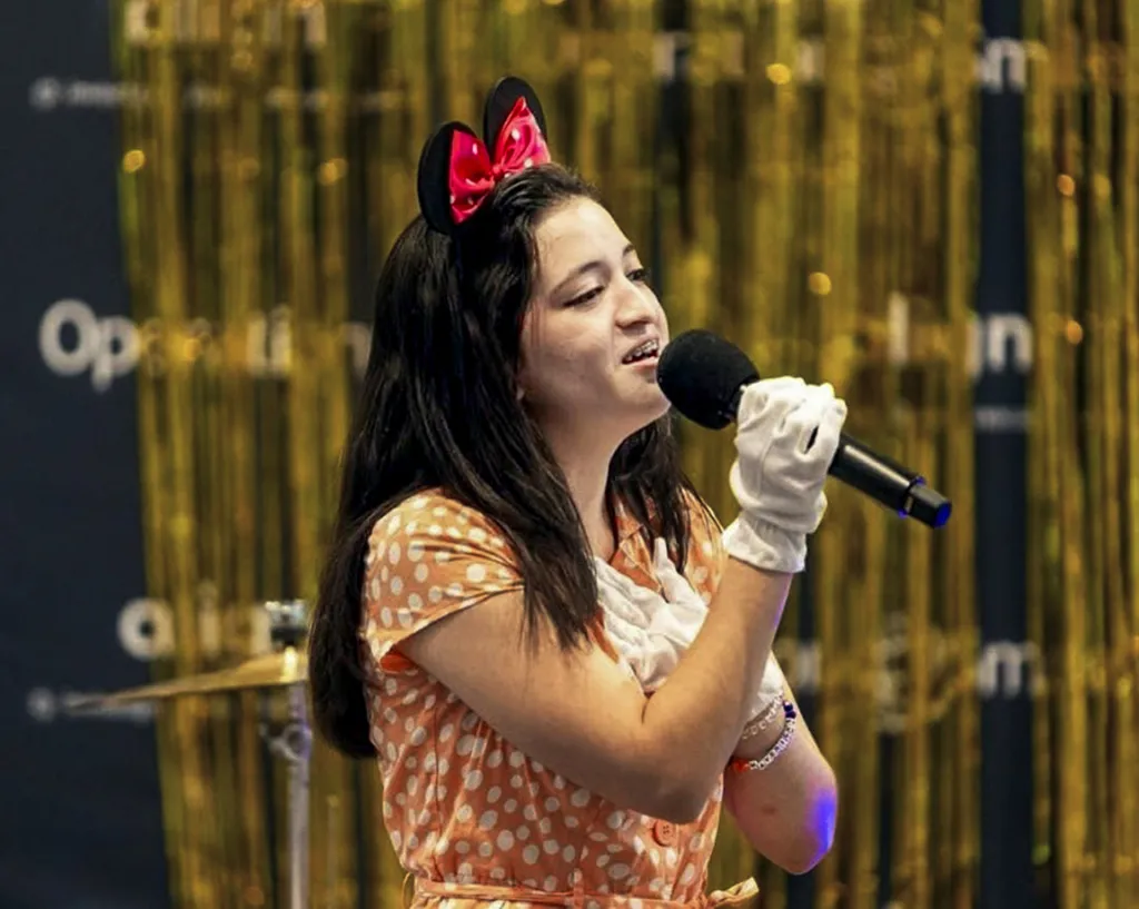 Angie sings into a microphone during an International Student Leadership Conference.