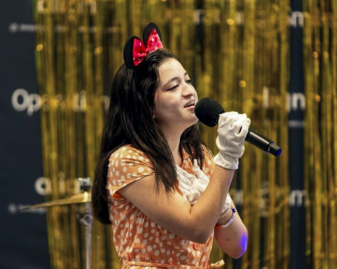Angie sings into a microphone during an International Student Leadership Conference.