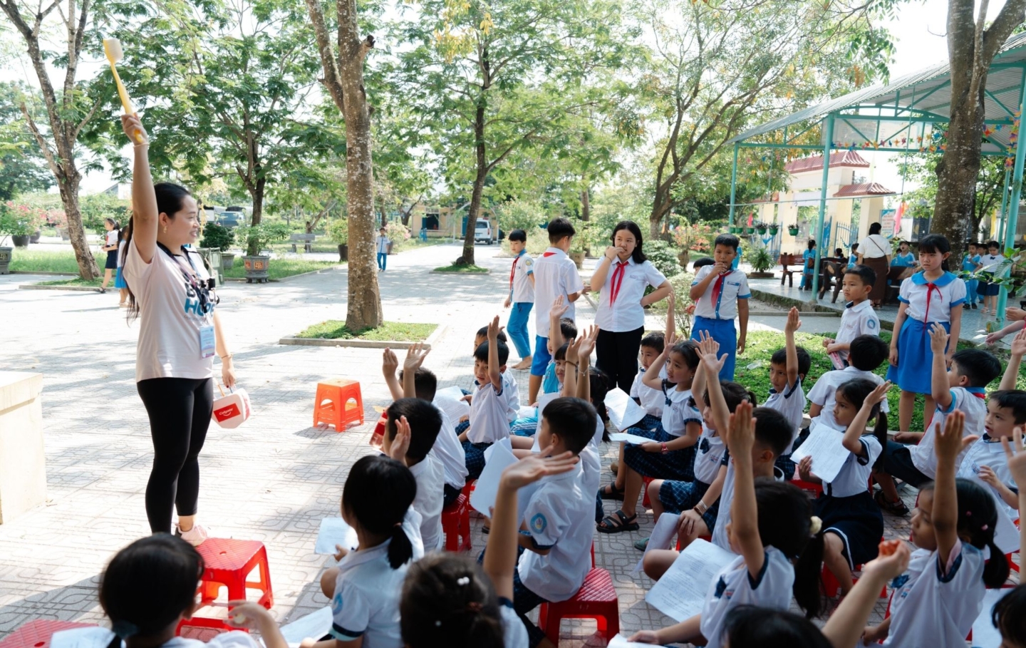 A volunteer speaks with students in Vietnam during a dental program.
