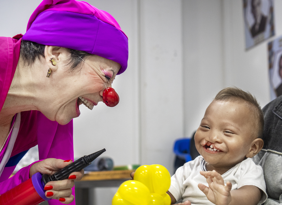Ihan laughs while playing with a member of Clowns without Borders.