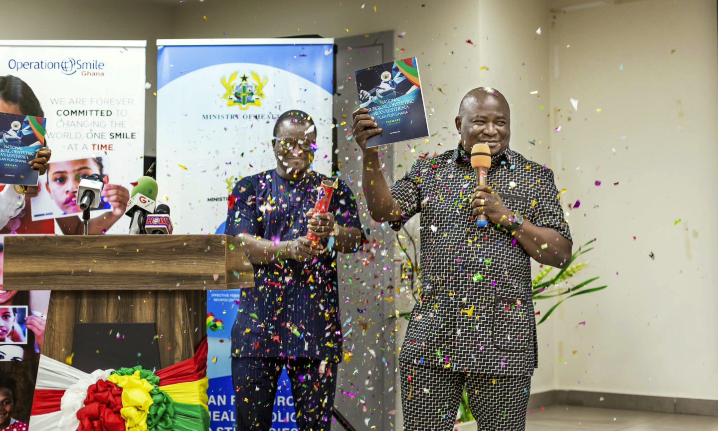 Two men celebrate the launch of Ghana's National Surgical, Obstetric and Anaesthesia Plan.