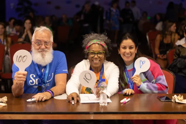 Three individuals smile during ISLC 2023.