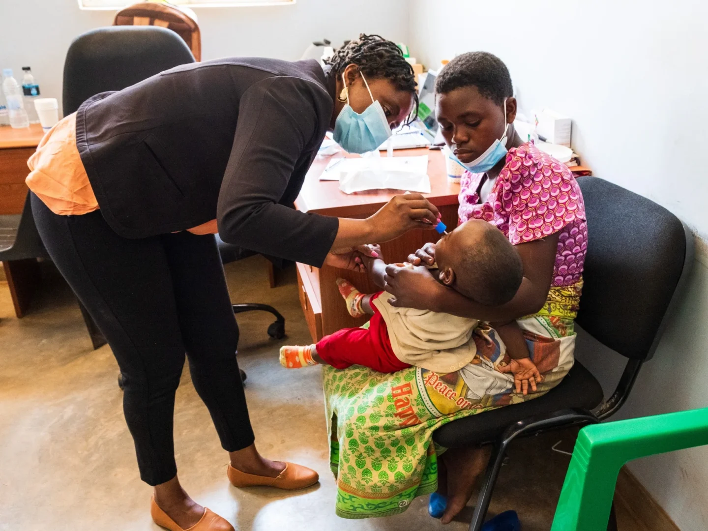 Five-year-old Michael sits patiently as Sharon, a plastic surgeon resident, takes a DNA sample.