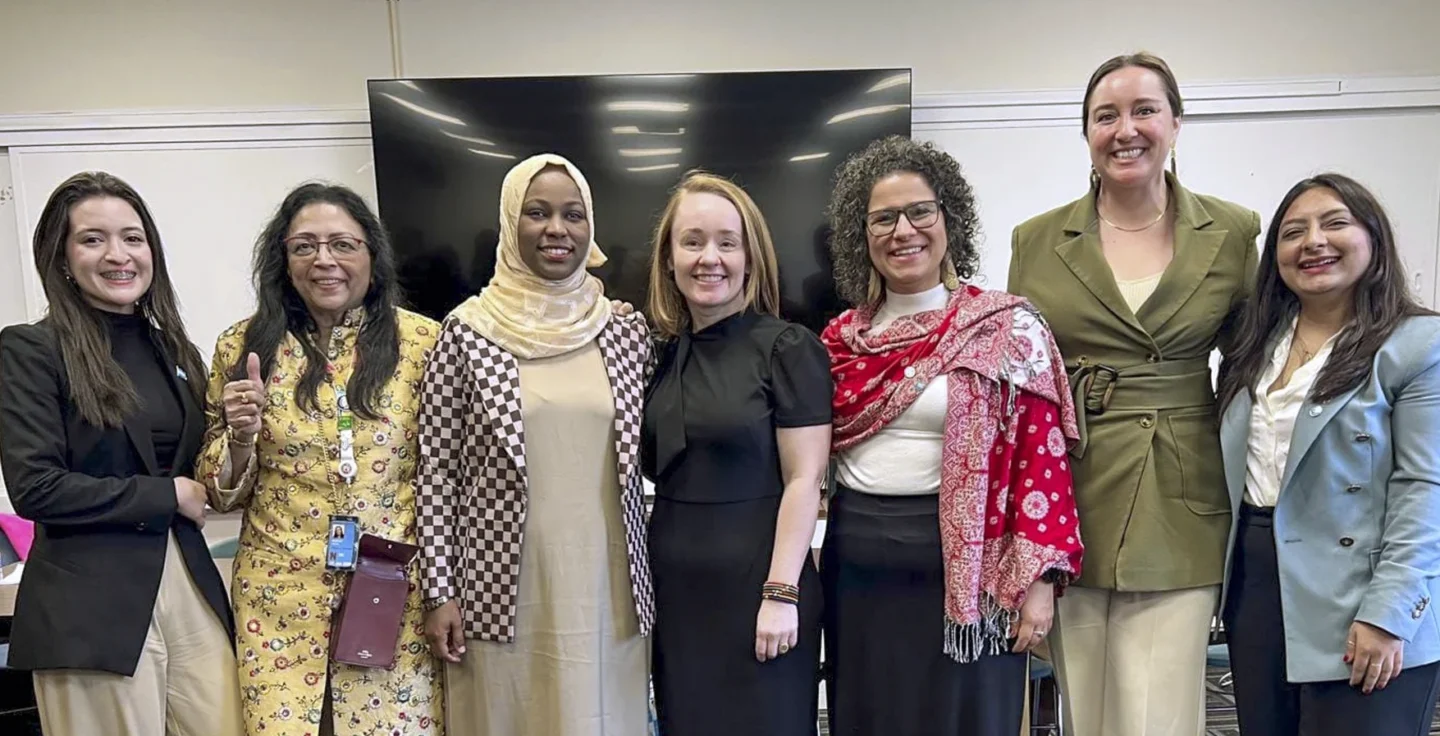 Participants at a roundtable event smile for the camera.