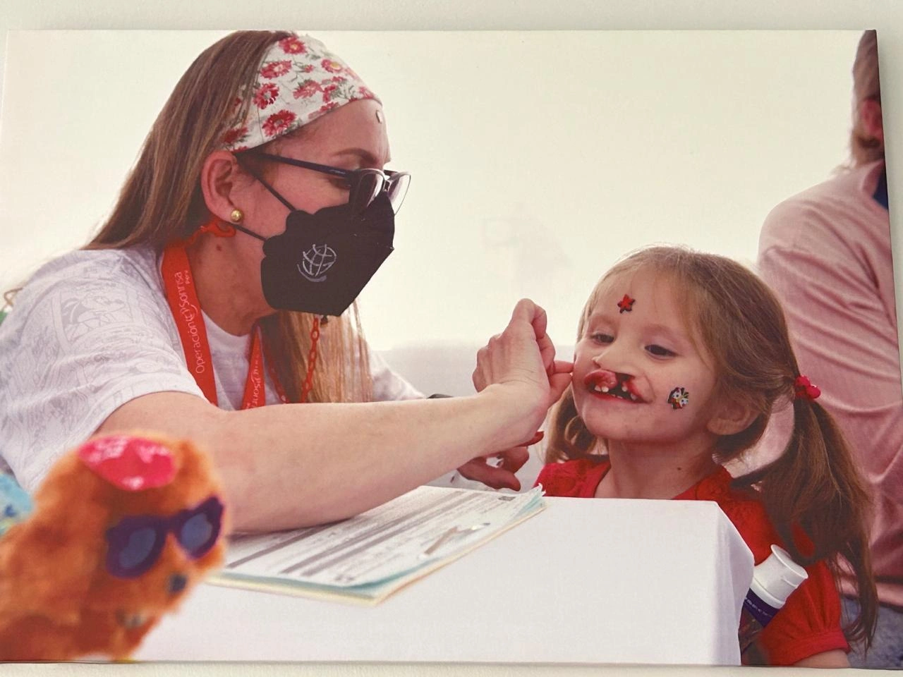 Speech therapist Milagros Rojas gives a patient a sticker.