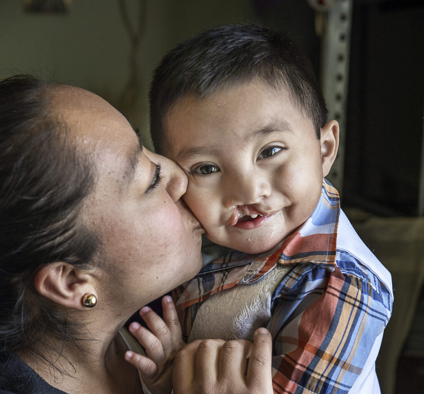 María gives her son, Sebastian, a kiss on the cheek.