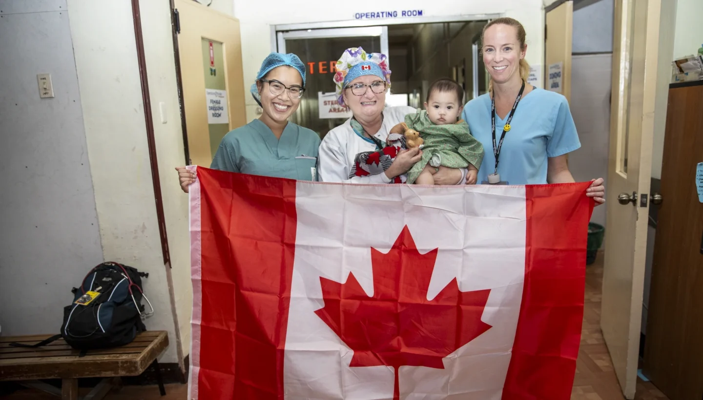 Canadian volunteers hold the flag and a patient.
