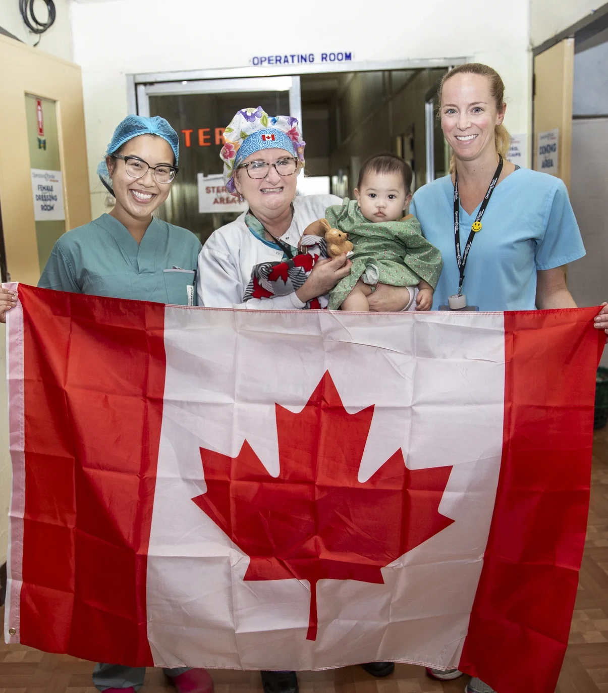 Canadian volunteers hold the flag and a patient.