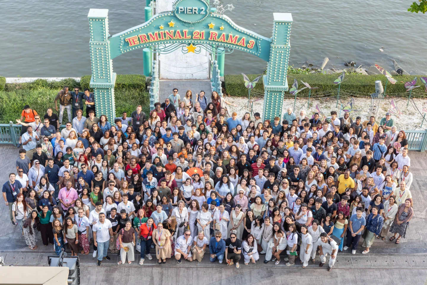 A group photo taken from above of the ISLC participants standing in at a pier in Bangkok, Thailand.